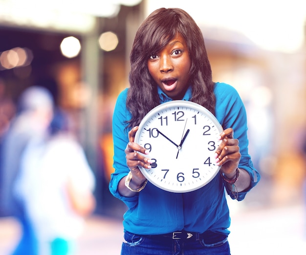 Chica sorprendida con un reloj grande