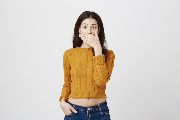 Chica sorprendida y sorprendida jadeando, taparse la boca y mirar con asombro