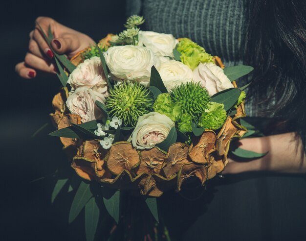 Chica sosteniendo un concepto rústico de Navidad bouquet