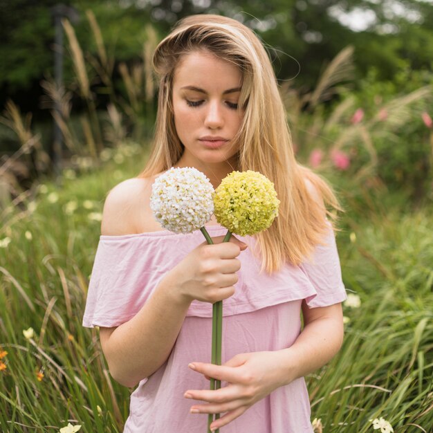 Chica sosteniendo flores brillantes en el parque