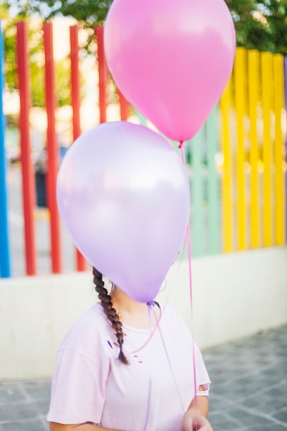 Chica sosteniendo globos