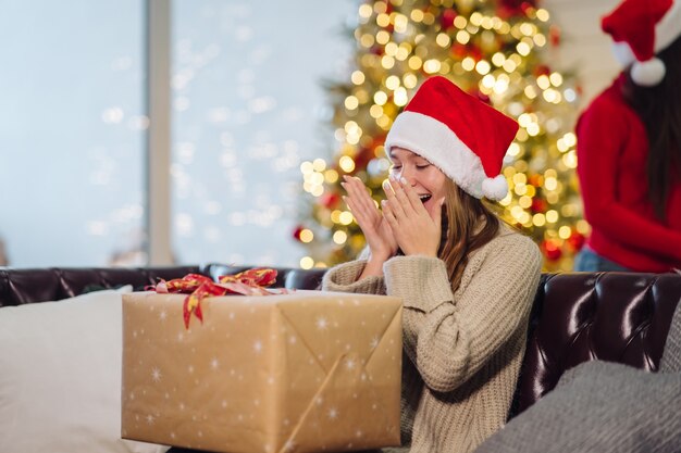 Chica sosteniendo un regalo de Navidad en Navidad.