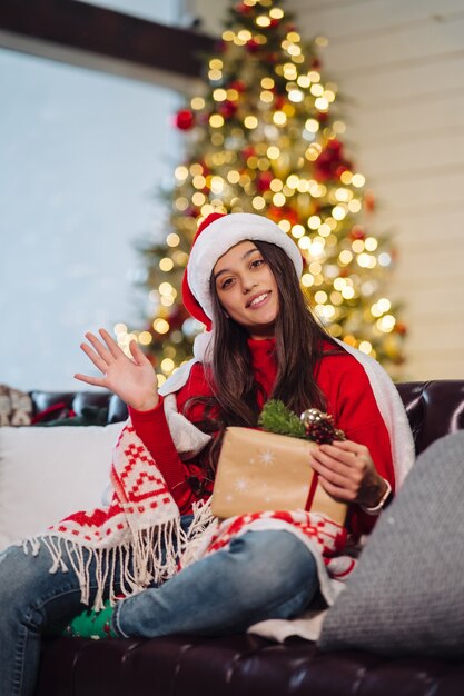 Chica sosteniendo un regalo de Navidad en Nochevieja.