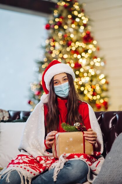 Chica sosteniendo un regalo de Navidad en Nochevieja.