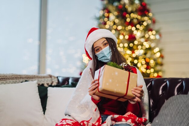 Chica sosteniendo un regalo de Navidad en Nochevieja.