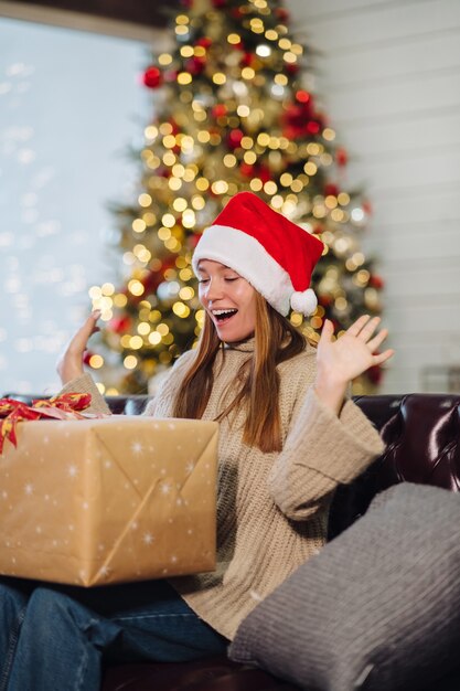 Chica sosteniendo un regalo de Navidad en Nochevieja.