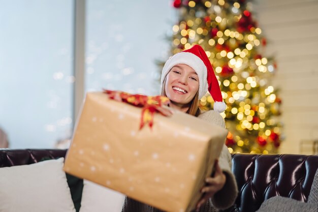 Chica sosteniendo un regalo de Navidad en Nochevieja.