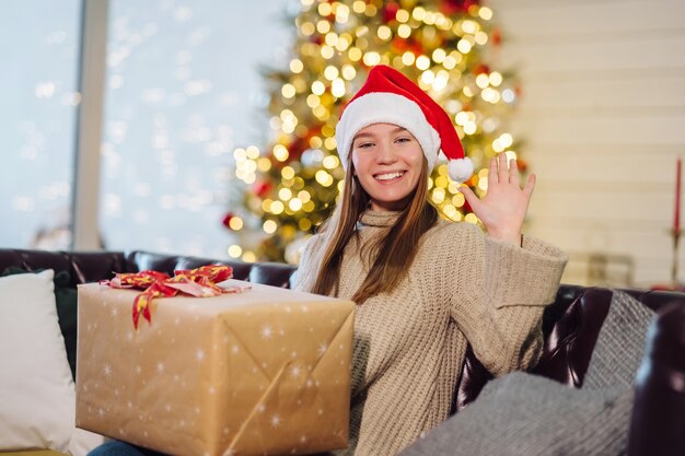 Chica sosteniendo un regalo de Navidad en Nochevieja.