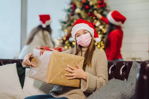 Chica sosteniendo un regalo de Navidad en Nochevieja.