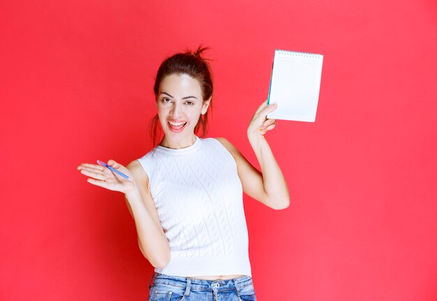 Chica sosteniendo su hoja de examen y apuntando a ella.