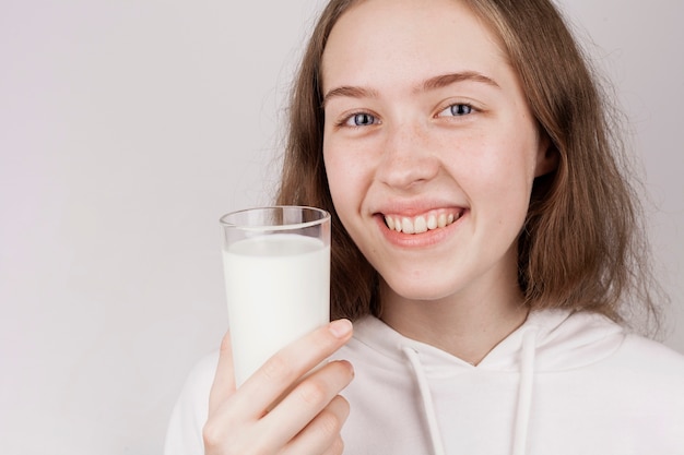 Chica sosteniendo un vaso de leche close-up