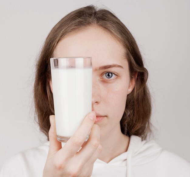 Chica sosteniendo un vaso de leche fresca
