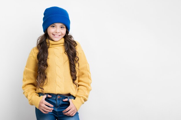 Chica con suéter amarillo y sombrero azul