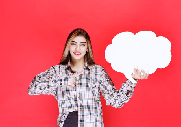 Chica en suéter cálido sosteniendo un tablero de ideas en forma de nube y presentando el desafío