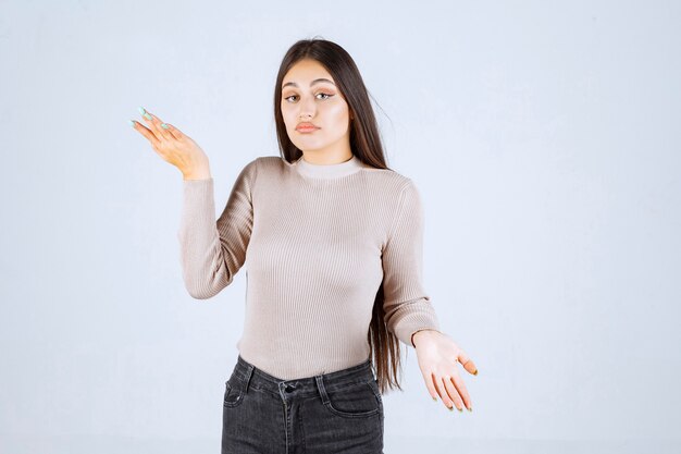 La chica de suéter gris se ve confundida y emocionada.