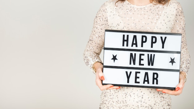 Chica sujetando cartel de feliz año nuevo