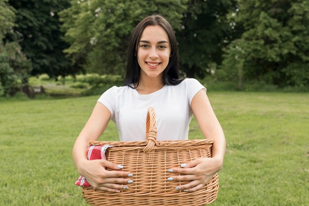 Chica sujetando cesta de picnic