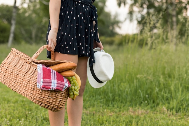 Chica sujetando cesta de picnic