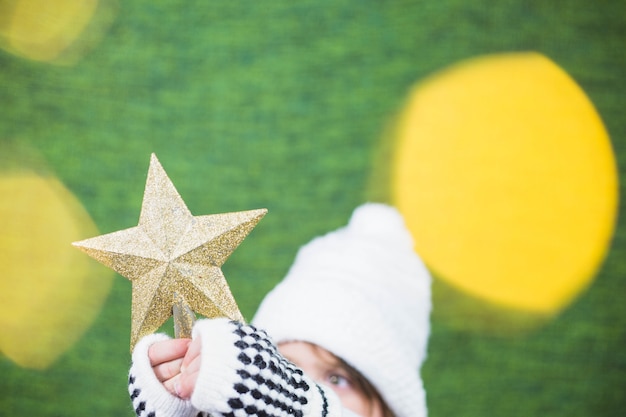 Foto gratuita chica sujetando estrella de navidad con efecto de luz