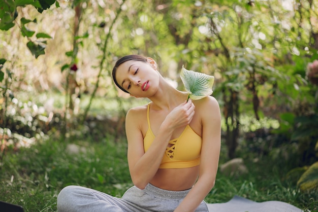 Chica sujetando una hoja verde cerca de su cara