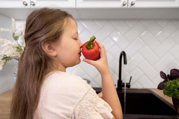 Chica sujetando vegetales de tiro medio