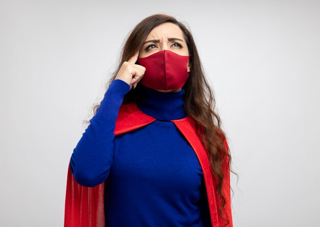 Chica de superhéroe caucásica confundida con capa roja con máscara protectora roja