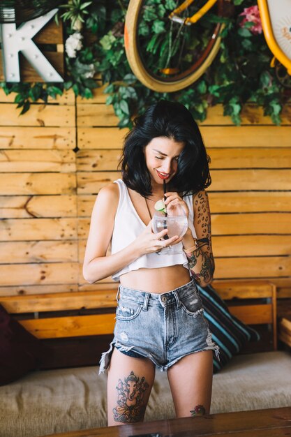 Chica con tatuaje bebiendo