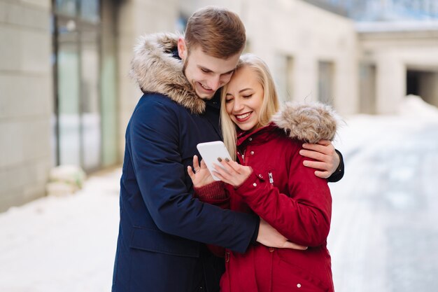 Chica con un teléfono en la mano y mirando el teléfono inteligente.