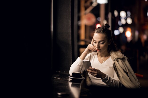 Chica con teléfono en la noche