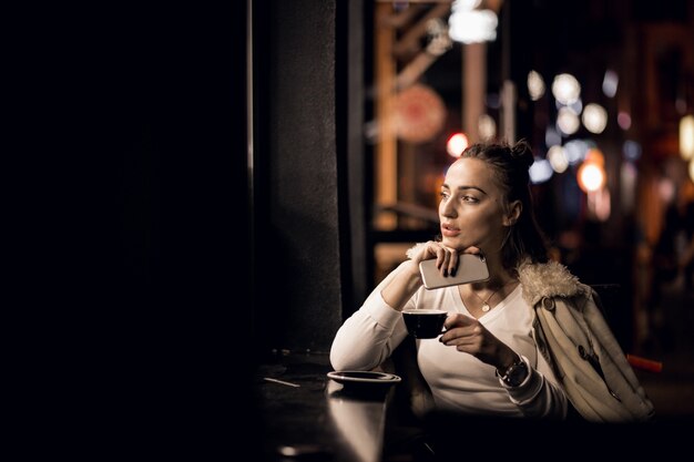 Chica con teléfono en la noche