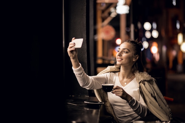 Chica con teléfono en la noche