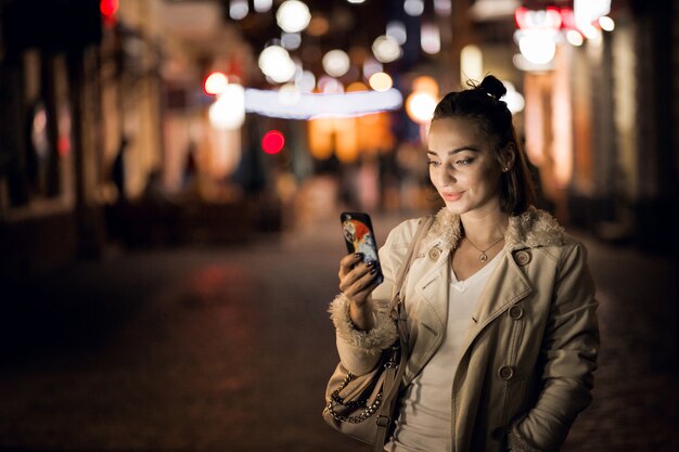 Chica con teléfono en la noche