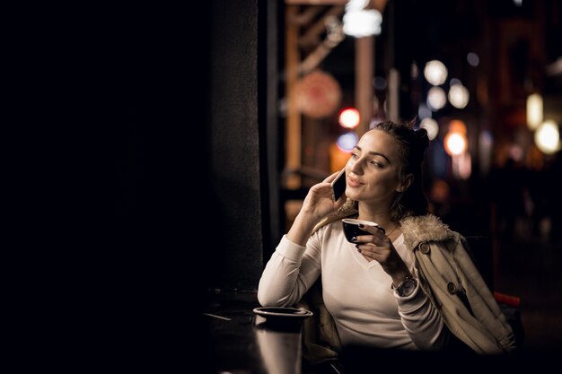 Chica con teléfono en la noche