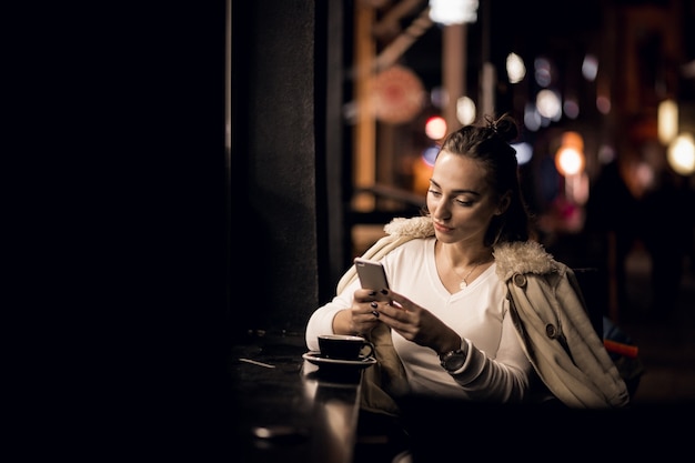 Chica con teléfono en la noche