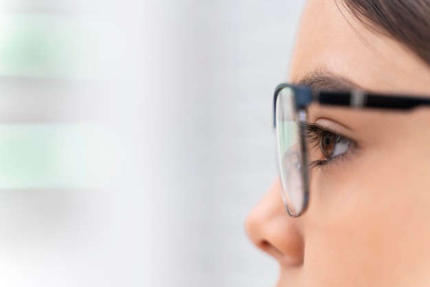 Foto gratuita chica en la tienda probándose gafas de cerca