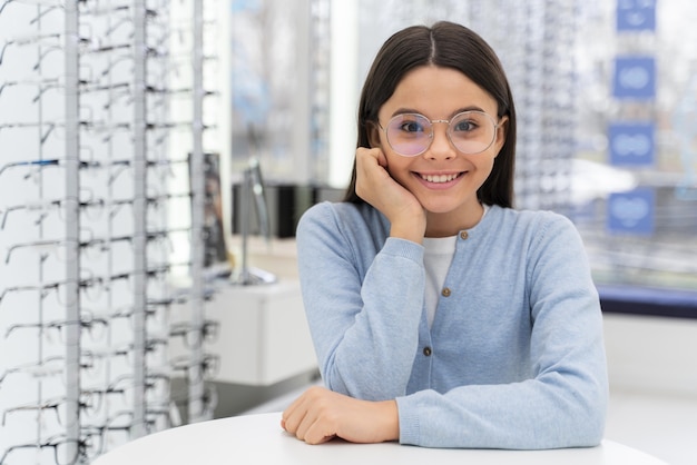 Chica en la tienda probándose gafas