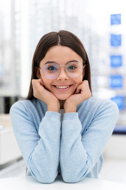 Chica en la tienda probándose gafas