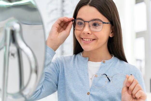 Chica en la tienda probándose gafas