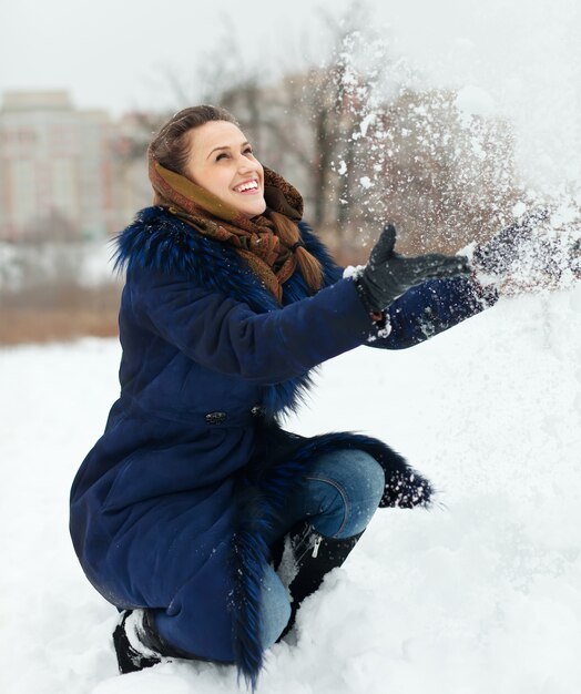 Chica tirando copos de nieve