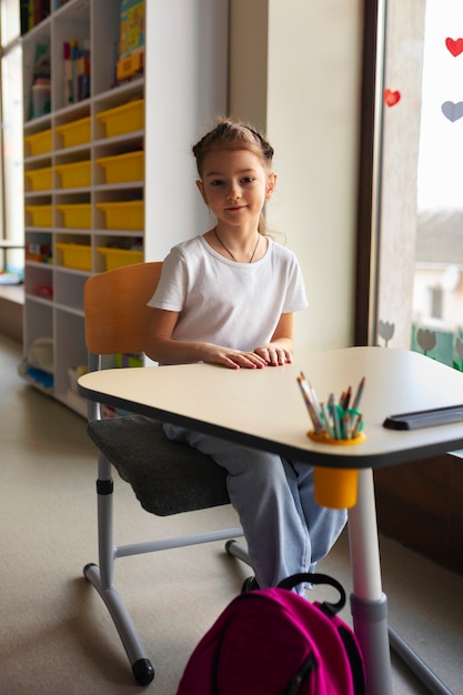 Chica de tiro completo aprendiendo en la escuela