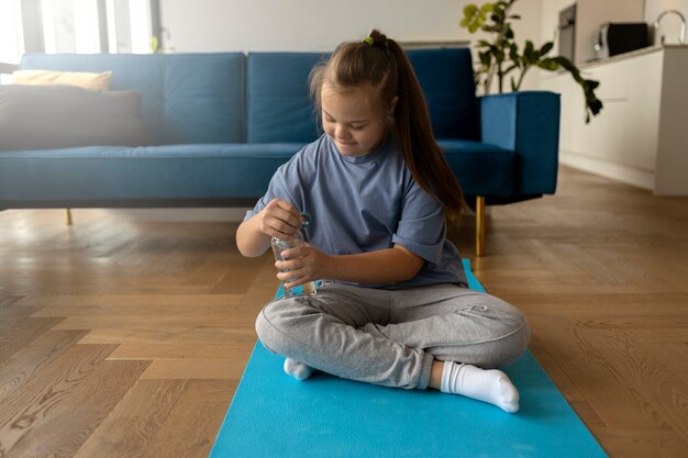 Chica de tiro completo con botella de agua