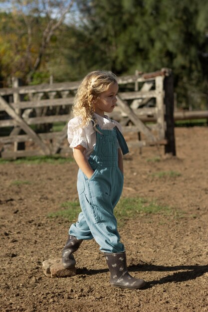 Chica de tiro completo caminando en la granja