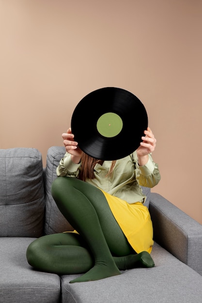 Foto gratuita chica de tiro completo con disco de vinilo