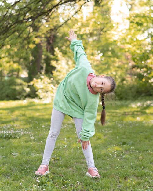 Chica de tiro completo haciendo ejercicio al aire libre