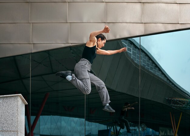 Chica de tiro completo haciendo entrenamiento de parkour