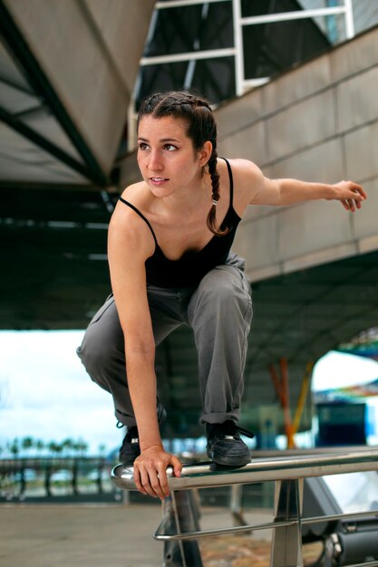 Chica de tiro completo haciendo entrenamiento de parkour