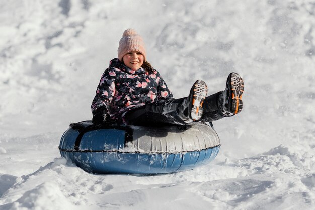 Chica de tiro completo jugando en la nieve