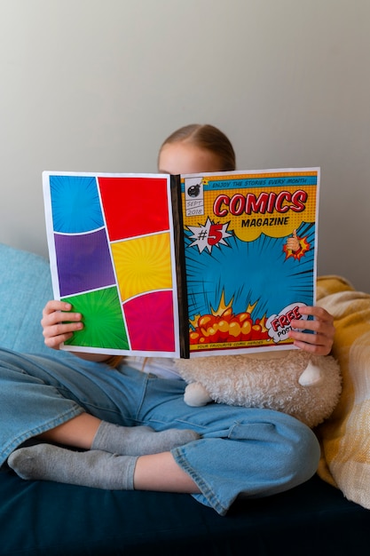 Foto gratuita chica de tiro completo leyendo cómics en el interior