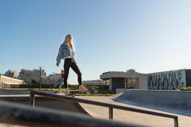 Foto gratuita chica de tiro completo en patineta al aire libre