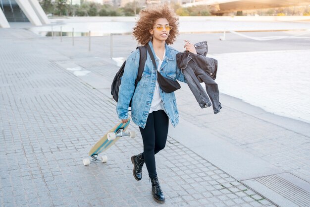 Chica de tiro completo con patineta